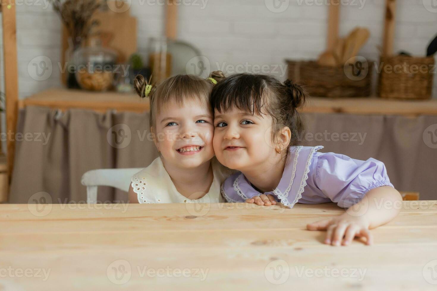 little happy girls fool around in the kitchen and eat apples photo