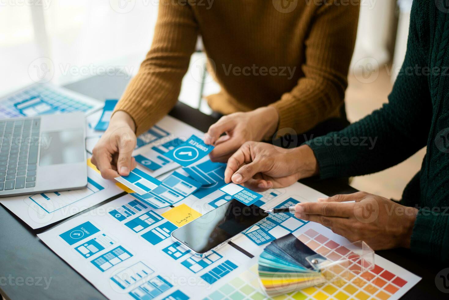 UX developer and ui designer brainstorming about mobile app interface wireframe design with customer breif and color code at modern office. photo