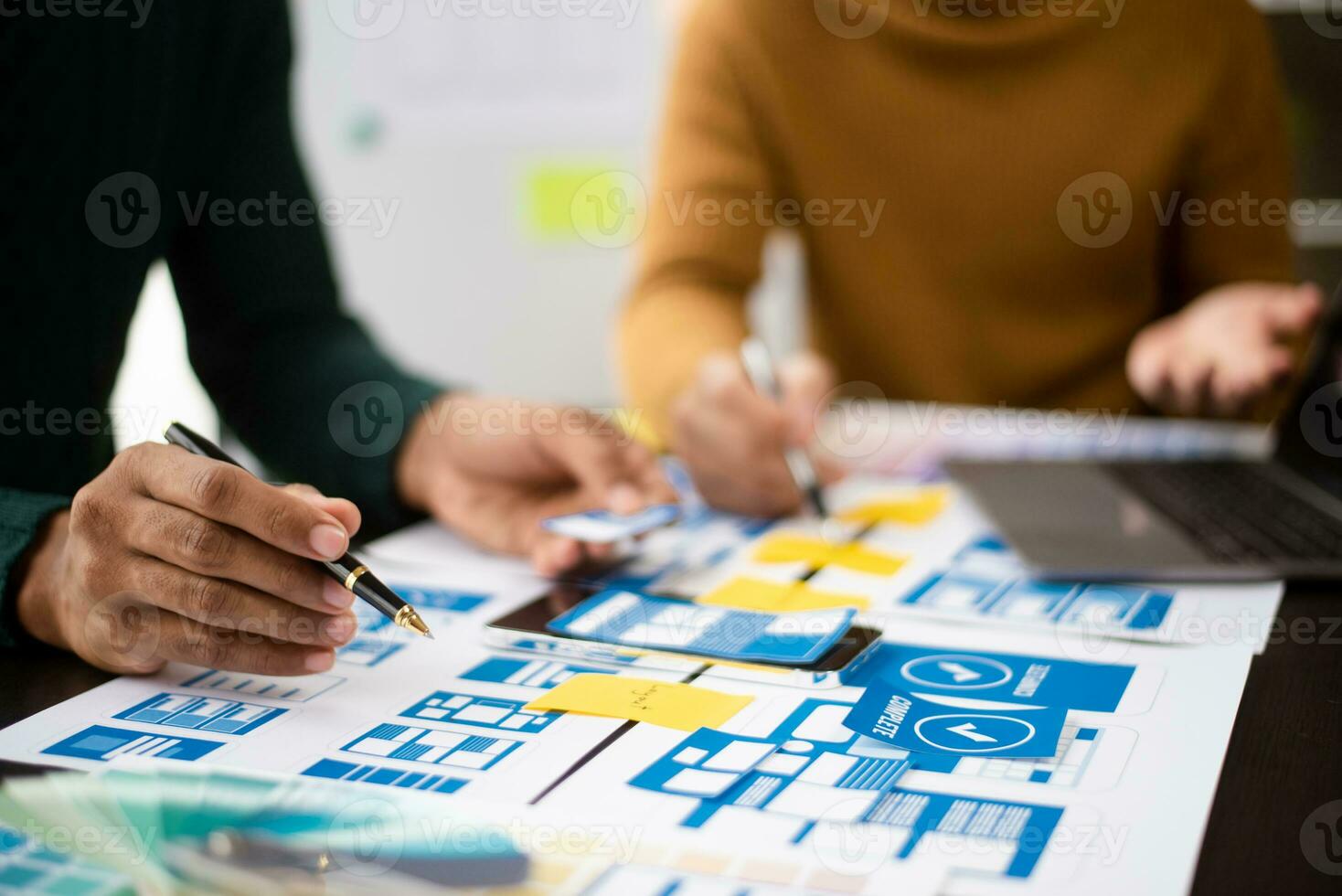 UX developer and ui designer brainstorming about mobile app interface wireframe design with customer breif and color code at modern office. photo