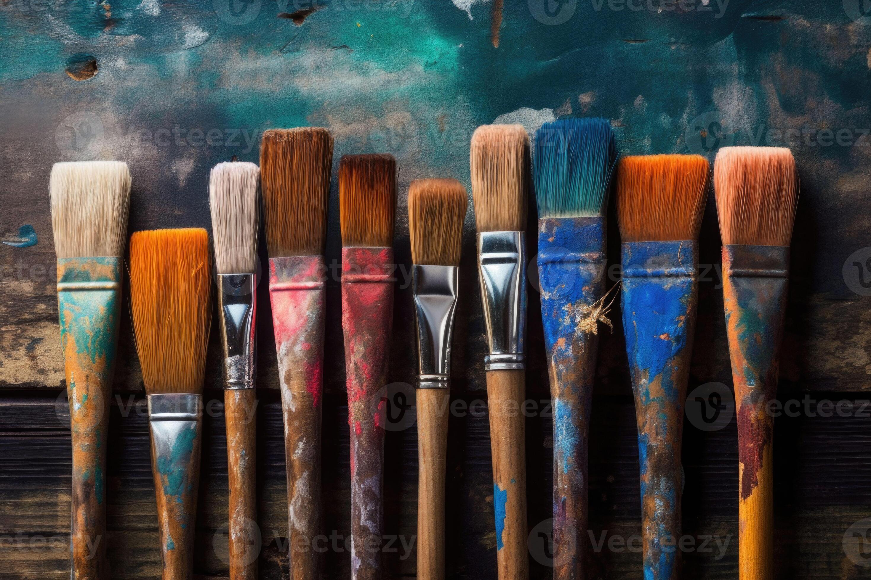 Row of used paintbrushes closeup on wooden background. Brushes with