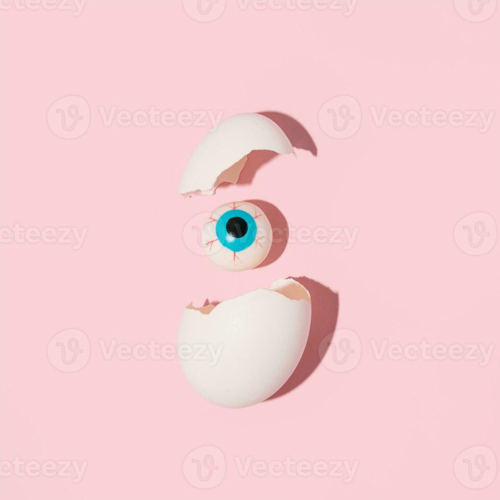 White egg shells and eye ball, creative surreal layout. photo