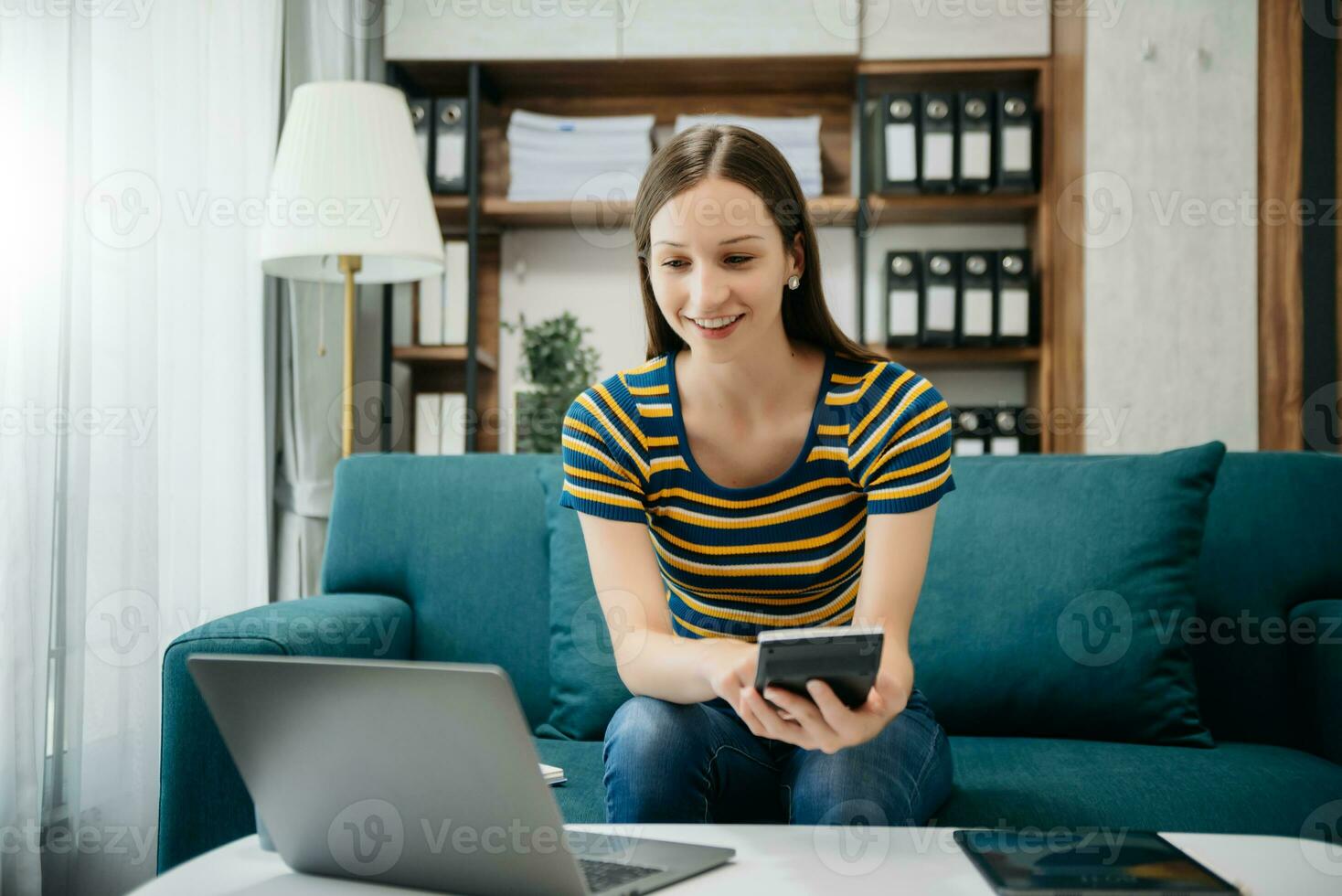 Caucasian businesswoman working in the office with working notepad, tablet and laptop documents on sofa in home office photo