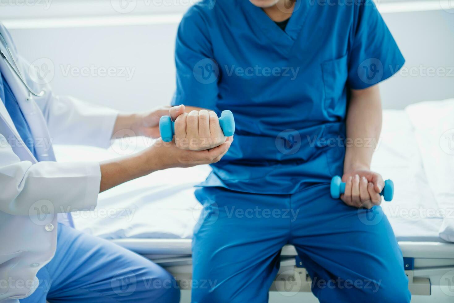 Asian physiotherapist helping male patient stretching arm during exercise correct with dumbbell in hand during training hand  in hospital photo