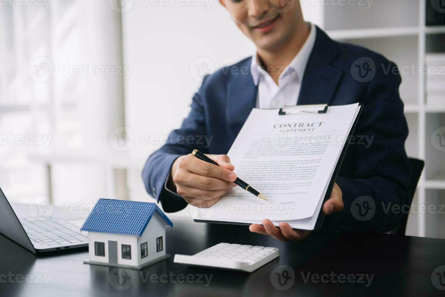 Real estate broker agent presenting to customer to decision making sign insurance form agreement, buy and sell home model, concerning mortgage loan offer photo