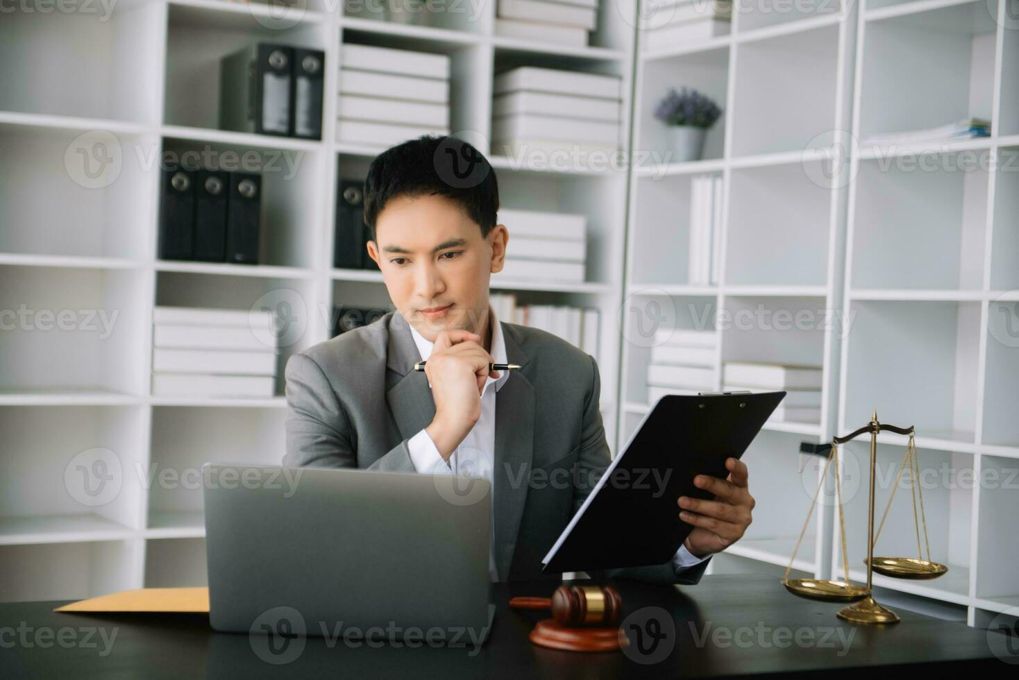 Attractive young lawyer in office Business man and lawyers discussing contract papers laptop and tablet with brass scale on  desk in office. photo