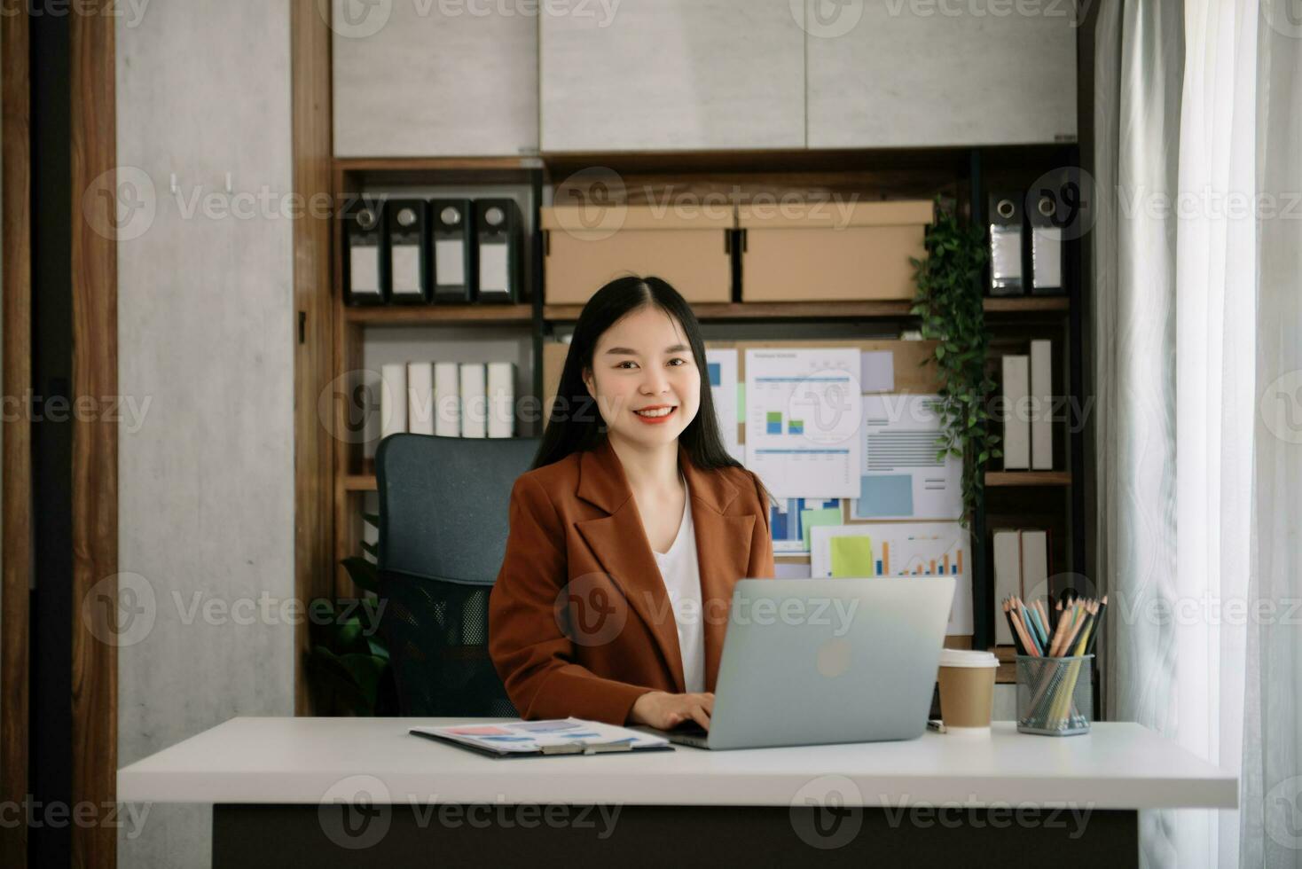 asiático joven mujer de negocios trabajando en el oficina con trabajando bloc, tableta y ordenador portátil documentos foto