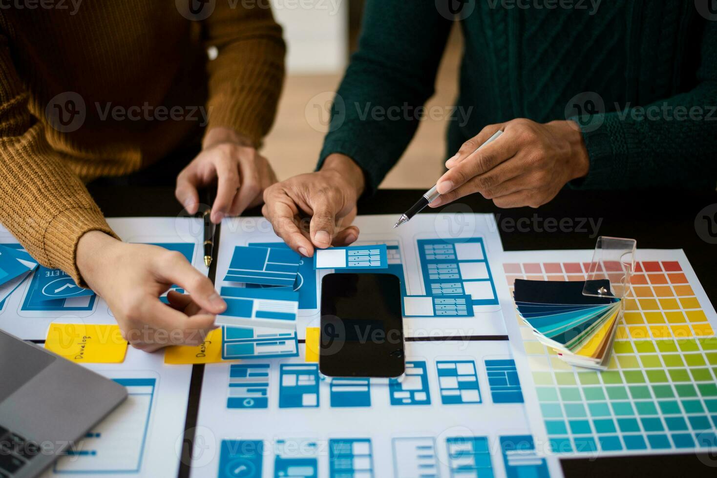 UX developer and ui designer brainstorming about mobile app interface wireframe design with customer breif and color code at modern office. photo