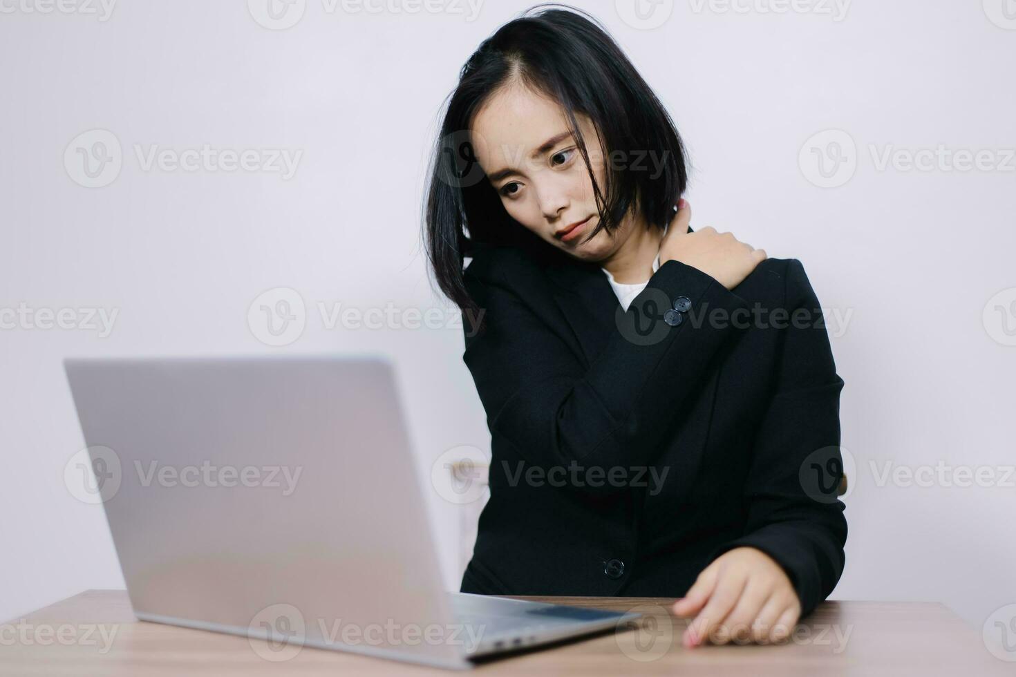 Concept Office Syndrome, Young Asian female office worker is tired from hard work, shoulder pain due to working hours consecutively. photo