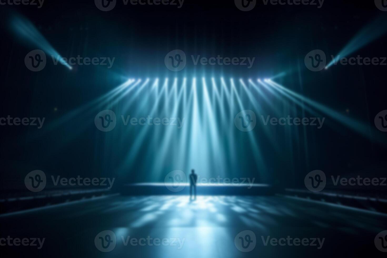 blurred a person standing on center of stage in big hall with lighting background. photo