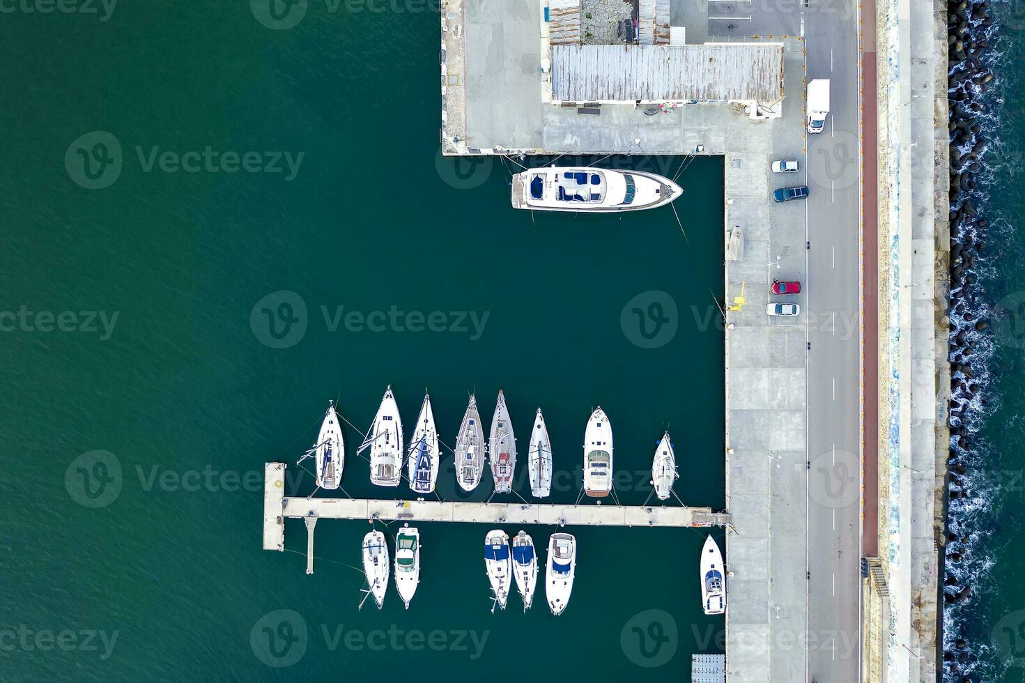 Top View by drone of yachts and small motor boats on the harbor. Yacht and sailboat are moored at the quay. photo