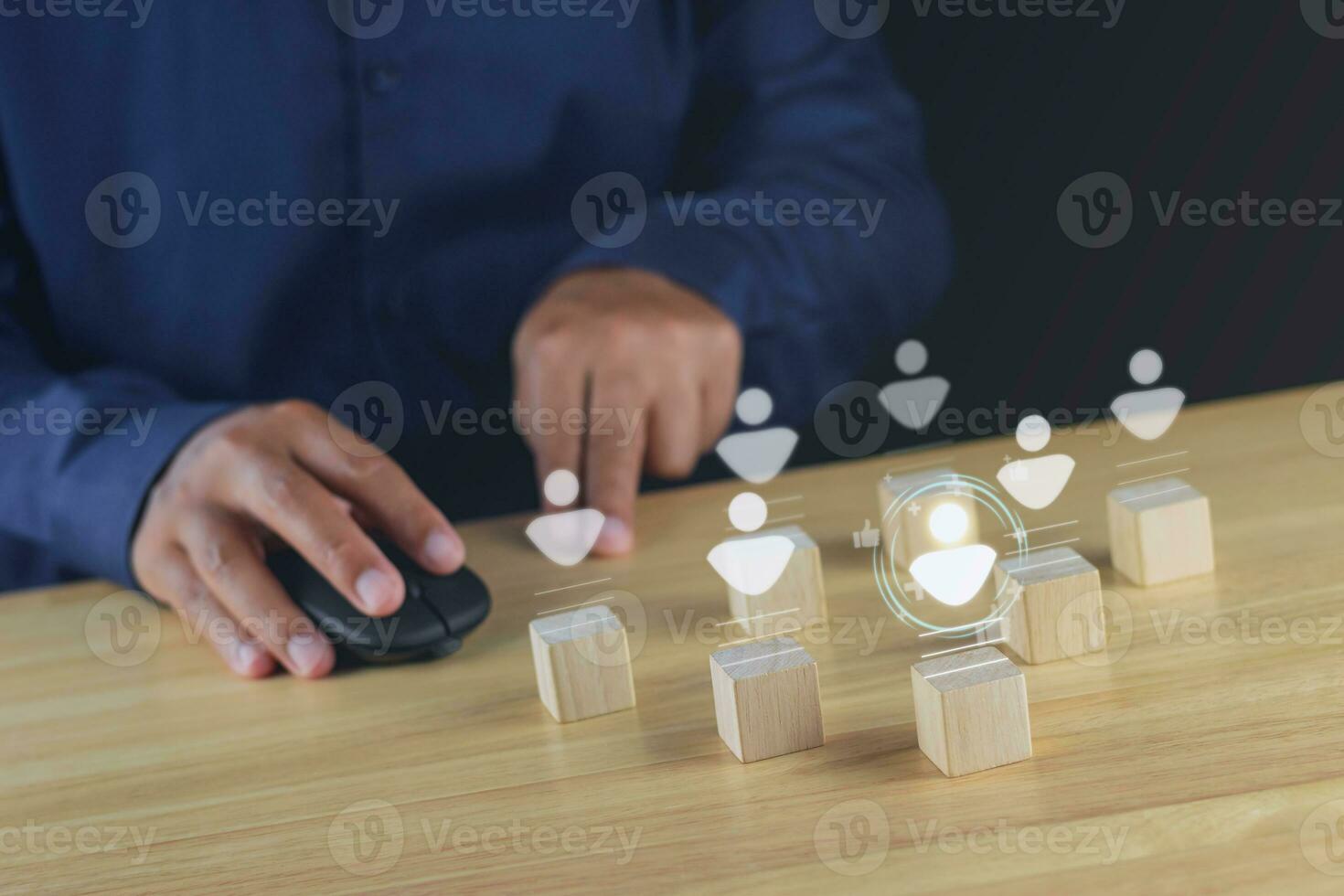 Recruitment concept. Human Resource Manager chooses new people to join an organization or support a cause. Holograms are happened on wood cube. photo