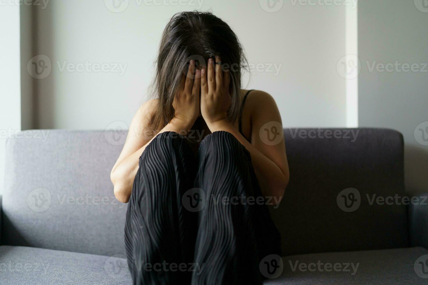 Sad woman thinking about problems sitting on a sofa upset girl feeling lonely and sad from bad relationship or Depressed woman disorder mental health. photo