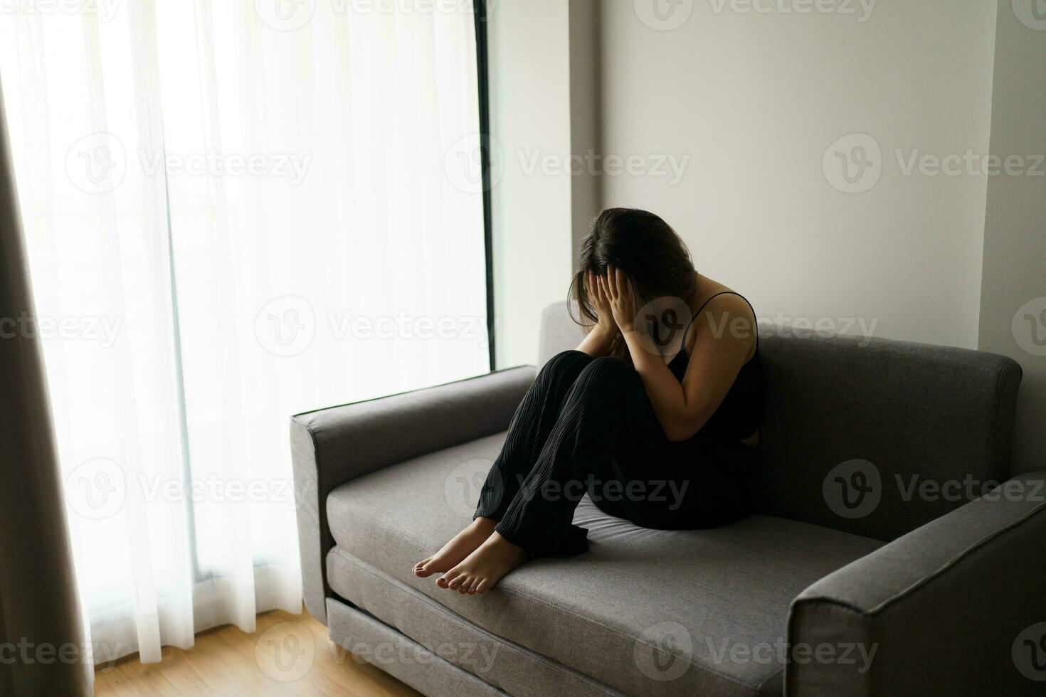 Sad woman thinking about problems sitting on a sofa upset girl feeling lonely and sad from bad relationship or Depressed woman disorder mental health. photo