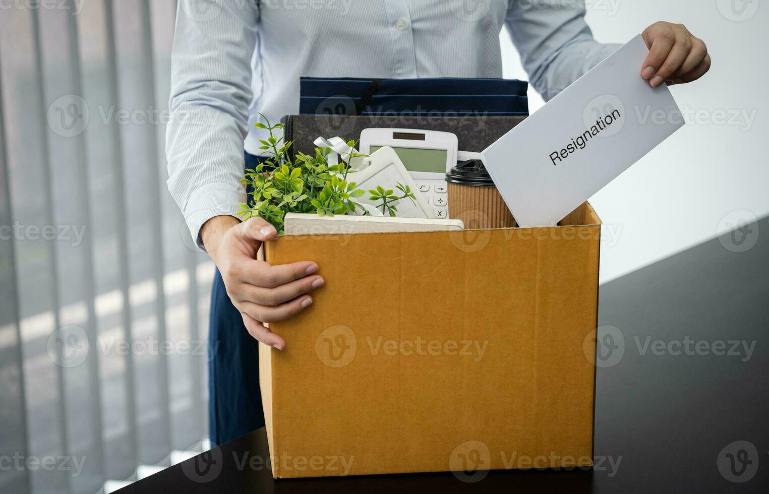 Business woman sending resignation letter and packing Stuff Resign Depress or carrying business cardboard box by desk in office. Change of job or fired from company. photo