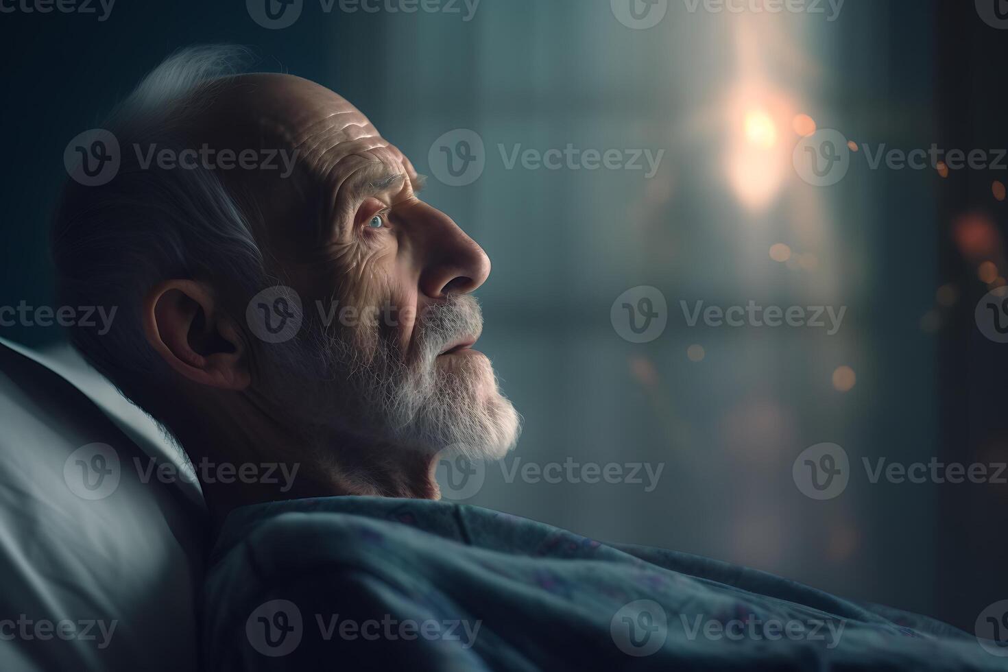 Elderly man lying in bed at home, looking at the window photo