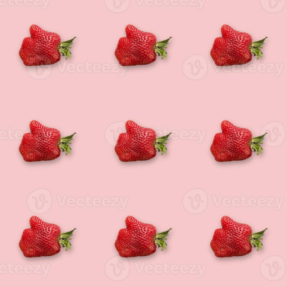 Fresh original strawberries on a pink background. Strawberries in the shape of a palm with a finger up. Realness photo