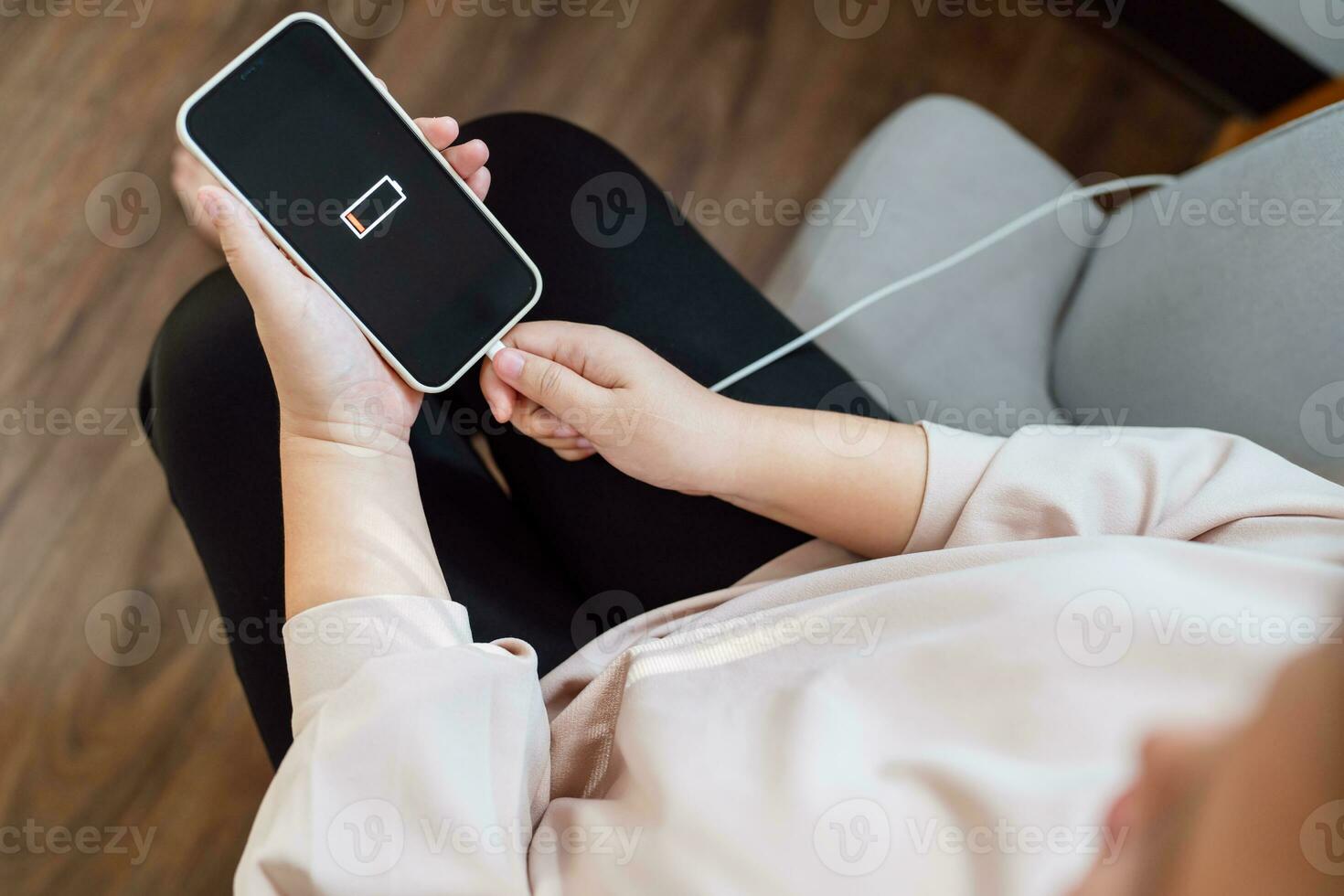 Woman hands Charging mobile phone battery with low battery. plugging a charger in a smart phone  with energy bank powerbank power charger Modern lifestyle energy technology concept photo