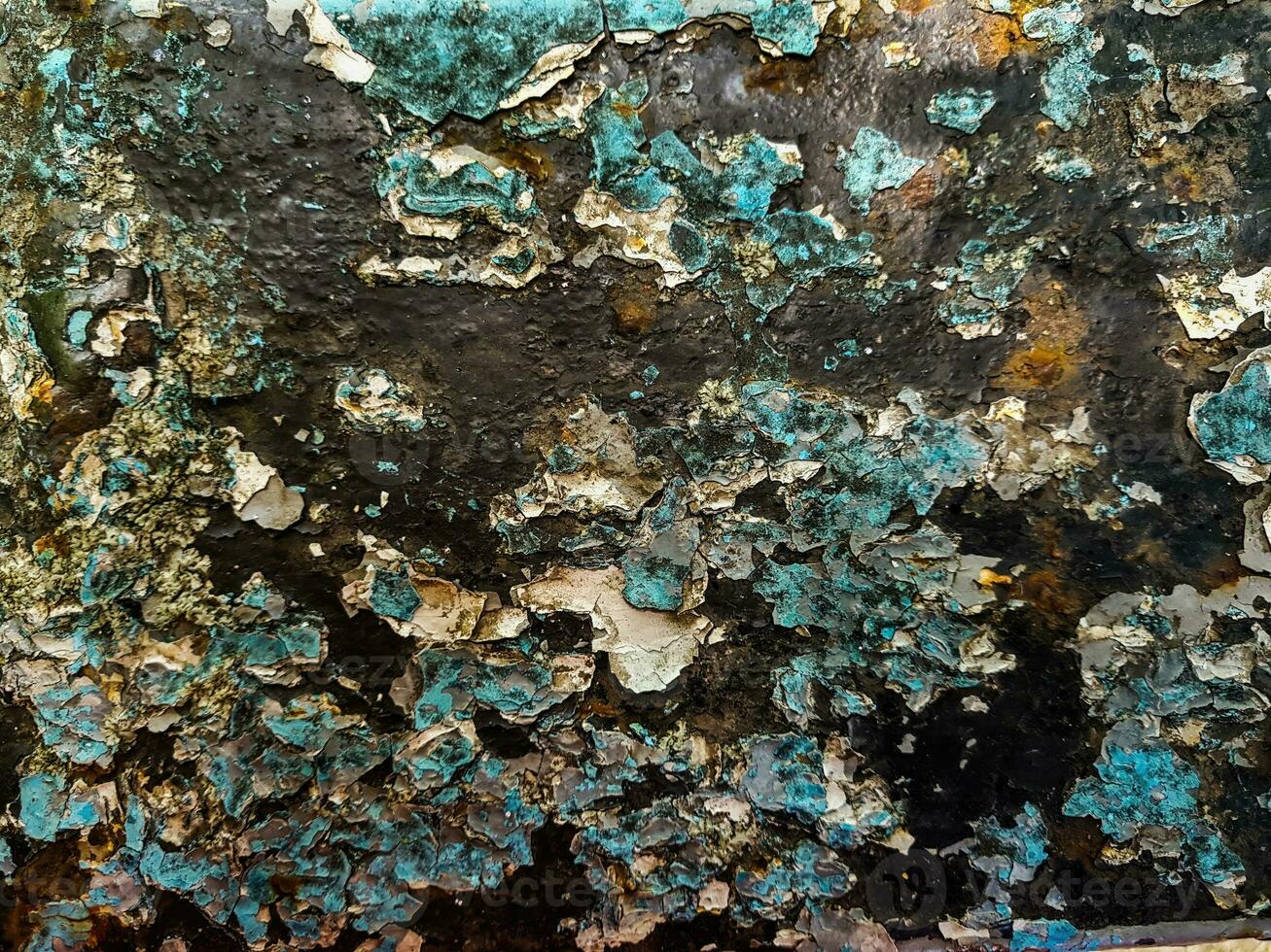 Blue peeling paint, rusty surface. Old rusty metal with cracked flaking enamel. Weathered rough painted surface with patterns of cracks and peeling. Texture for background and design.  Photo