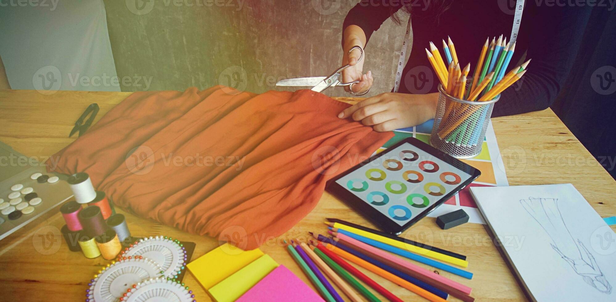 Stylish Fashion Designer Cutting Fabric of new collection in atelier. Creative Design Concept. photo
