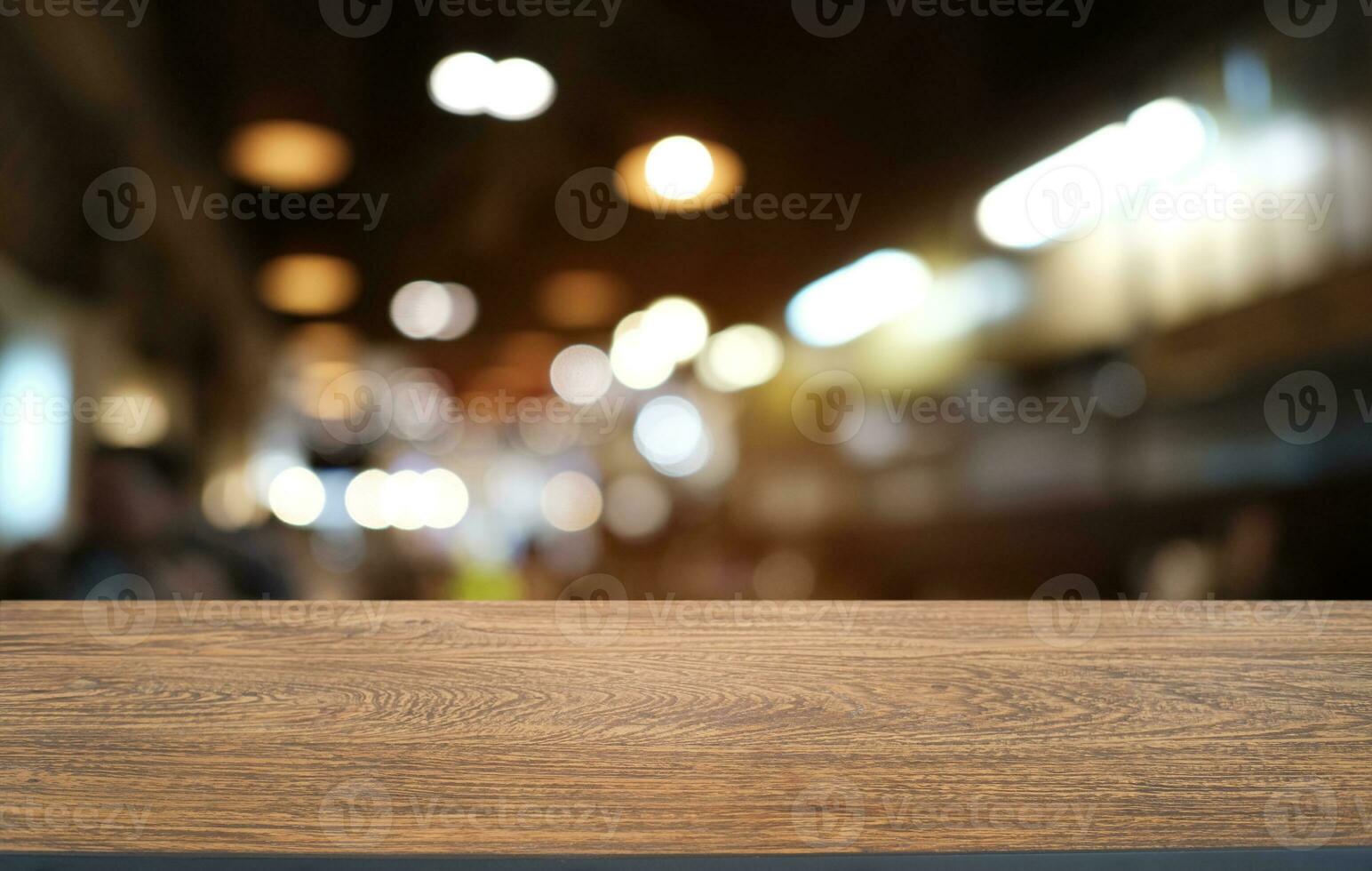 vacío oscuro de madera mesa en frente de resumen borroso bokeh antecedentes de restaurante . lata ser usado para monitor o montaje tu productos.mock arriba para espacio. foto