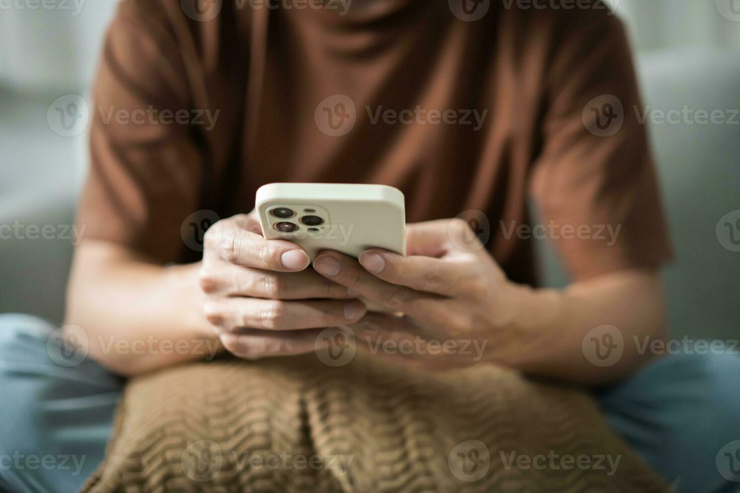 Relaxed young asian man using smart phone  spending time checking news social media photo
