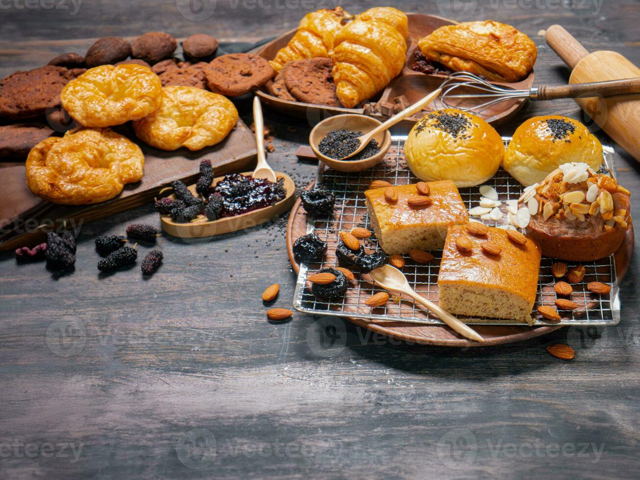 Top view of dessert table Bakery. Baking Bakery with berry jam, almond and poppy seeds. Bread, egg dessert, buns and croissants. photo