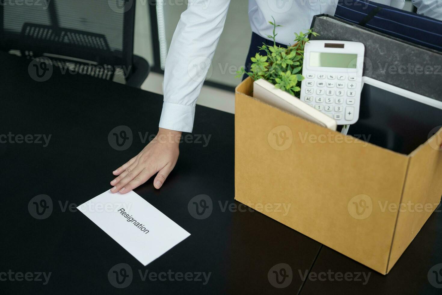Business woman sending resignation letter to boss and Holding Stuff Resign Depress or carrying cardboard box by desk in office photo
