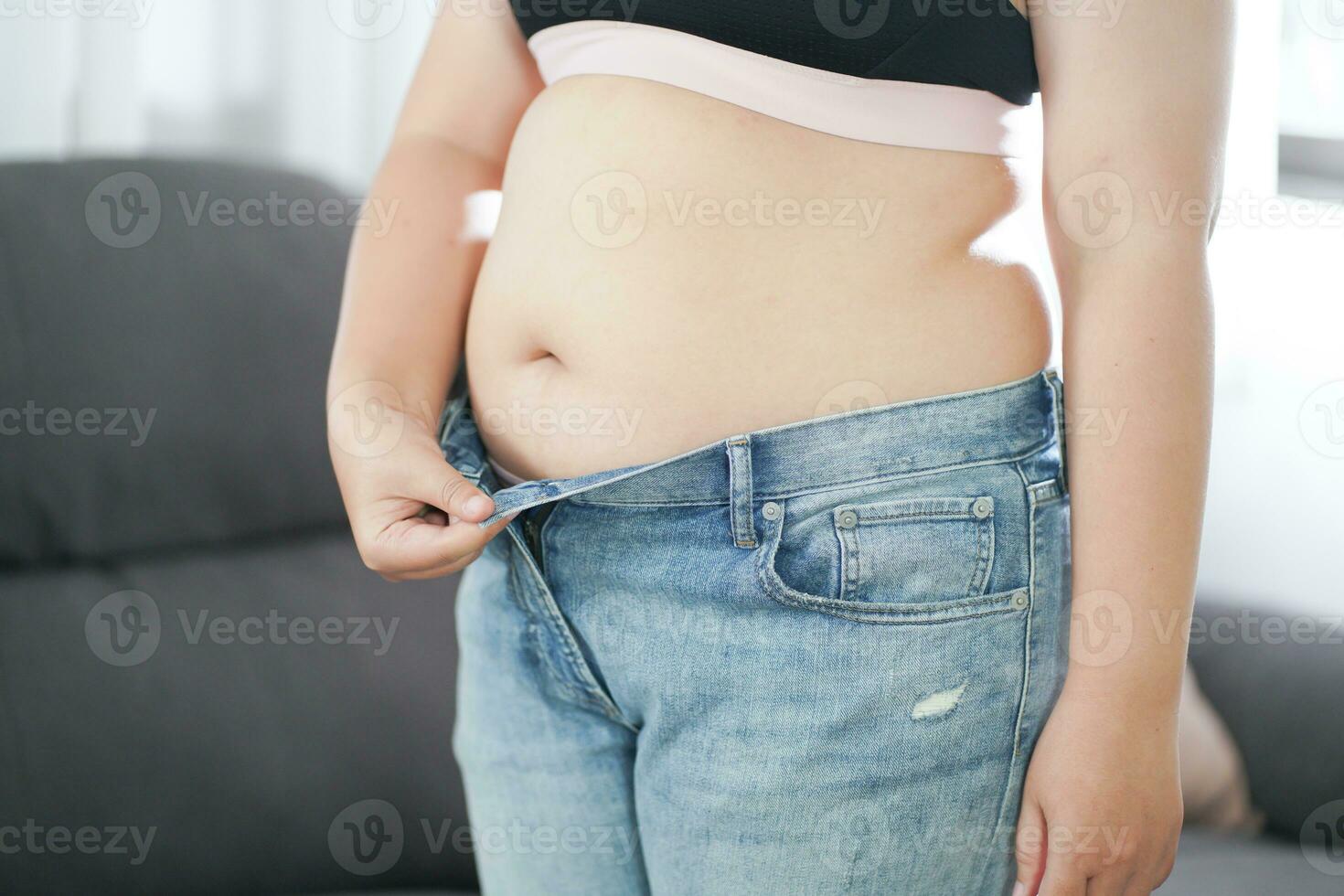 obeso mujer con grasa trastornado acerca de su barriga. exceso de peso mujer conmovedor su grasa barriga y querer a perder peso. grasa mujer con apretado ropa preocupado acerca de peso dieta estilo de vida concepto foto