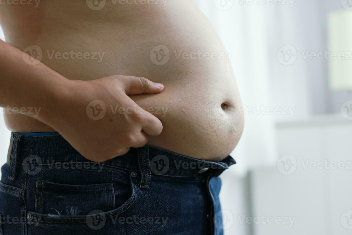 Man with fat belly in dieting concept. Overweight man touching his fat belly and want to lose weight. photo