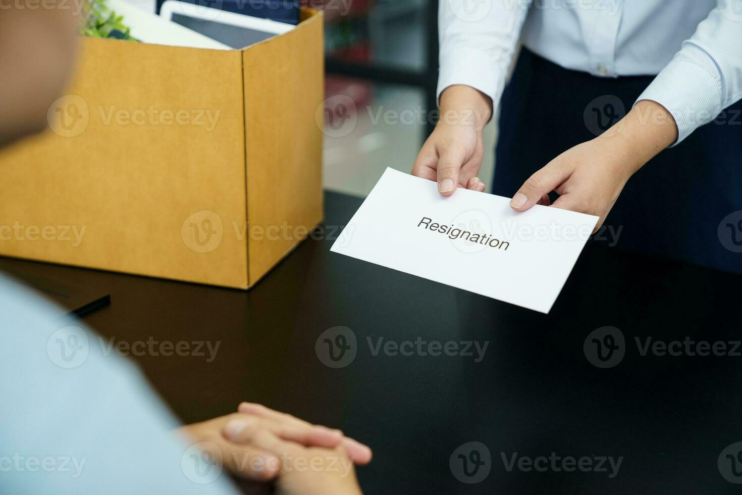 Business woman sending resignation letter to boss and Holding Stuff Resign Depress or carrying cardboard box by desk in office photo