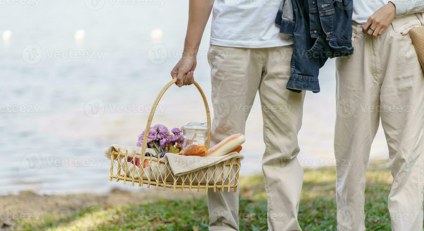 Couple walking in garden with picnic basket. in love couple is enjoying picnic time in park outdoors photo