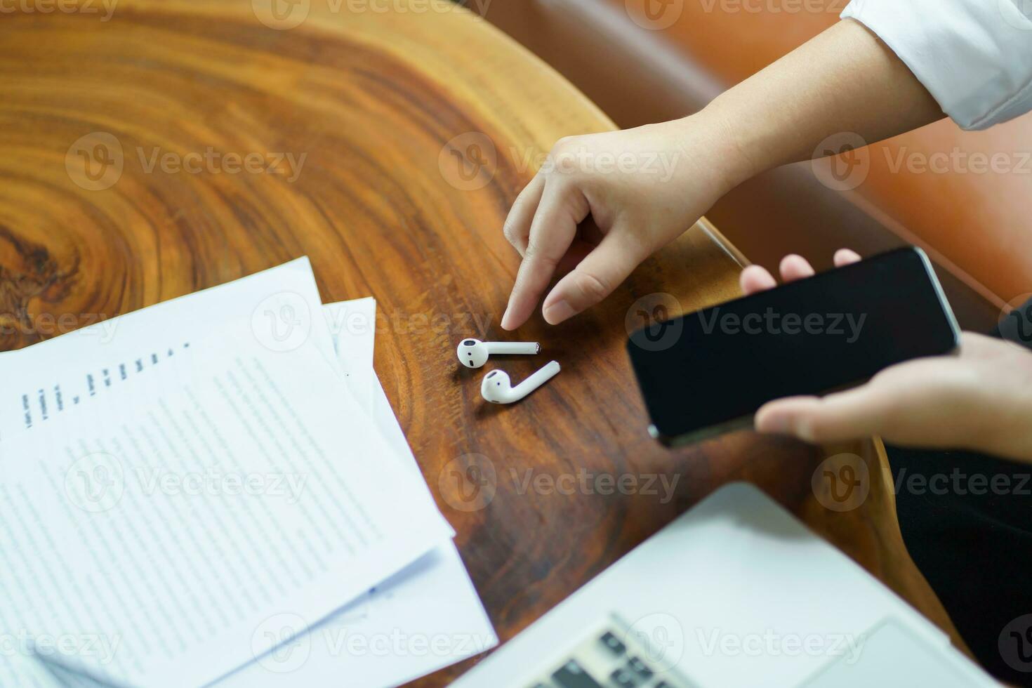 woman takes out wireless bluetooth headphones. earphones using smartphone photo