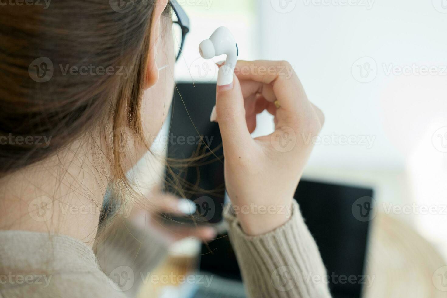 joven mujer utilizando inalámbrico auricular escuchando a música. foto