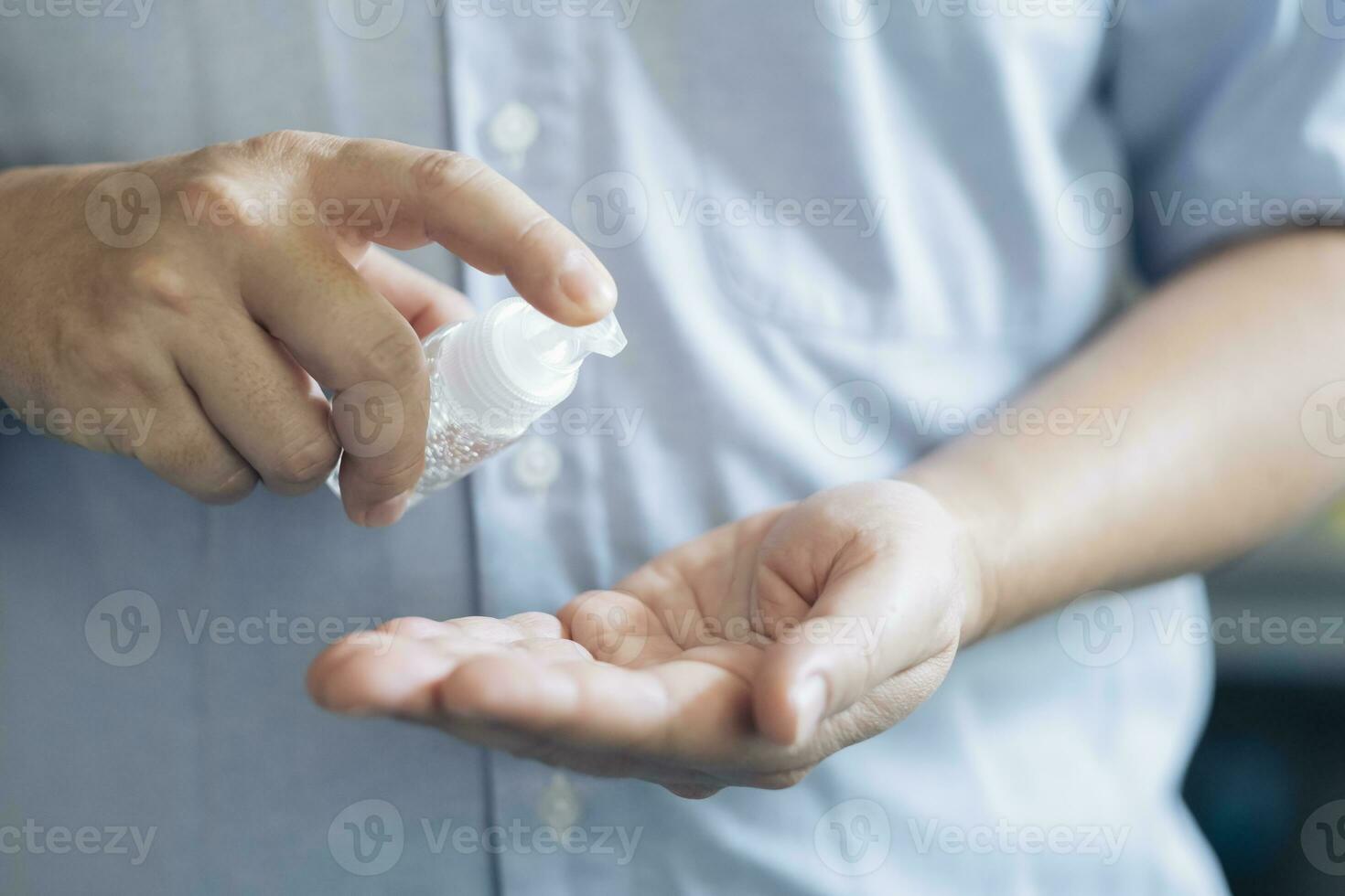 cerca arriba hombre manos utilizando lavar mano desinfectante gel dispensador. foto