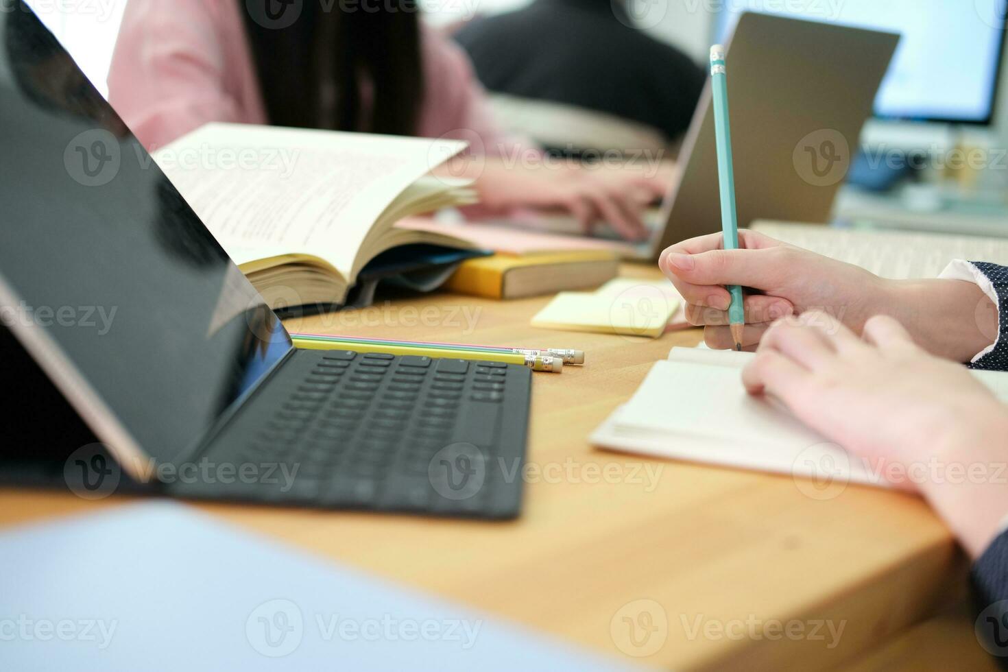 Young collage student using computer and digital tablet studying online. photo