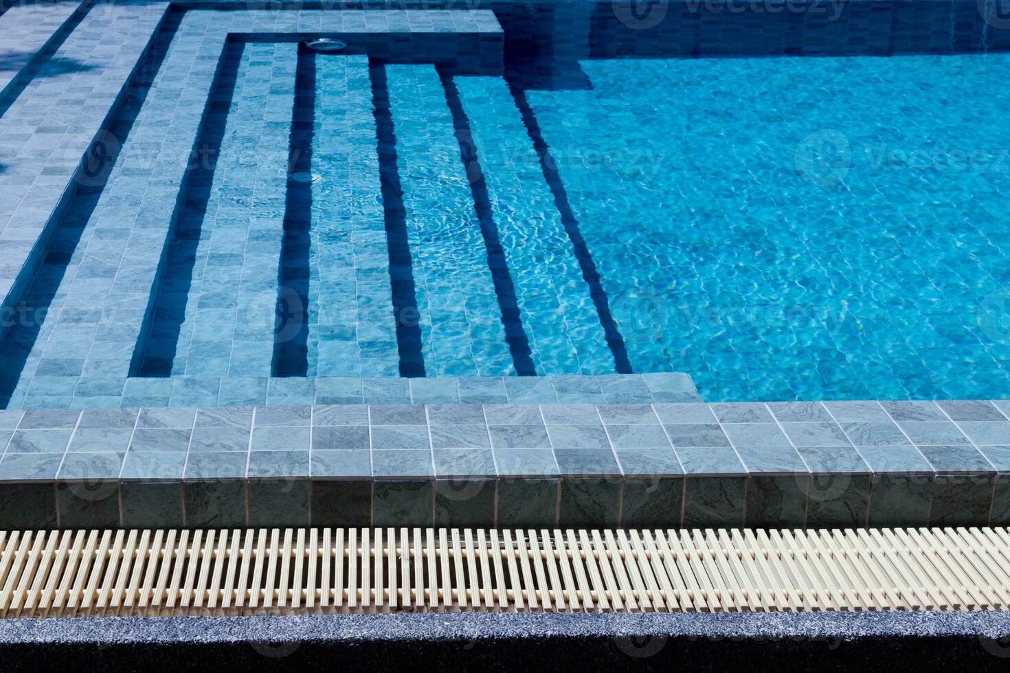 Outdoor swimming pool steps with clear water surface background, nobody, underwater pattern blue background with grid tiles, Summer background. photo