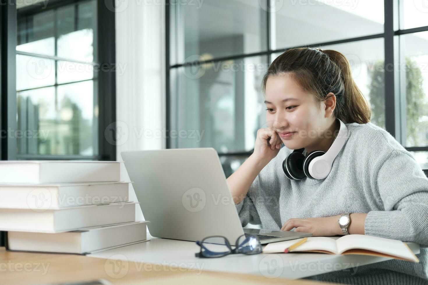 Young collage student using computer and mobile device studying online. photo