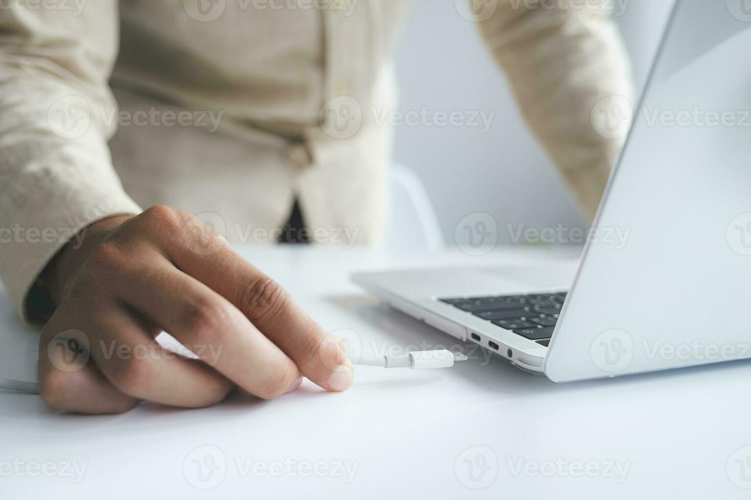 Persons hand inserting a USB cable charger into a computer. photo