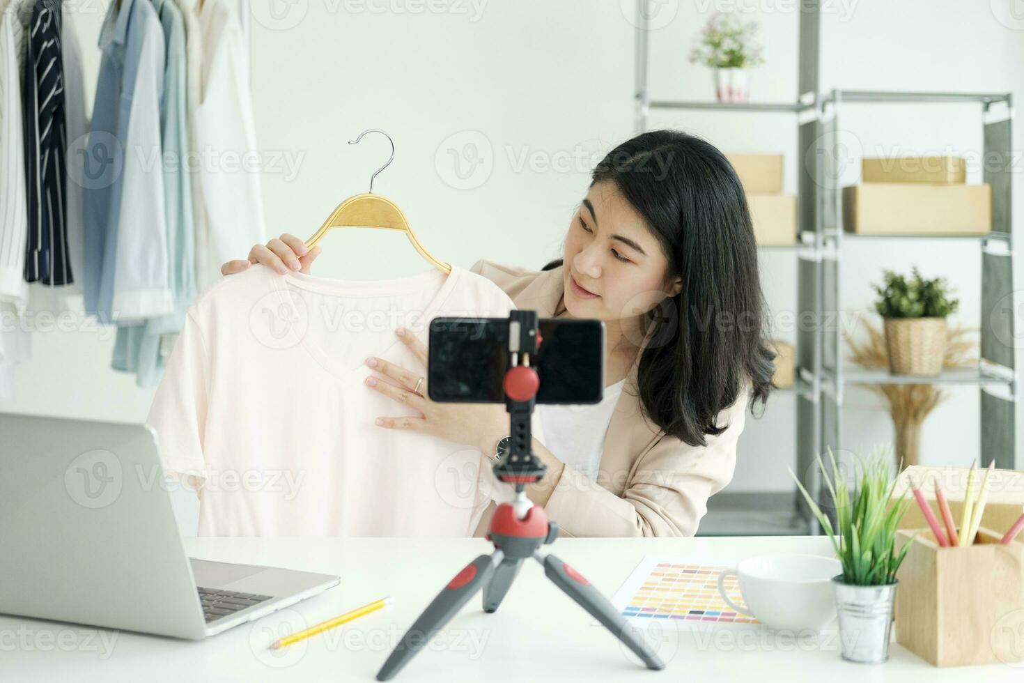 Businesswoman giving important pieces of advice while streaming video for women's clothing. photo