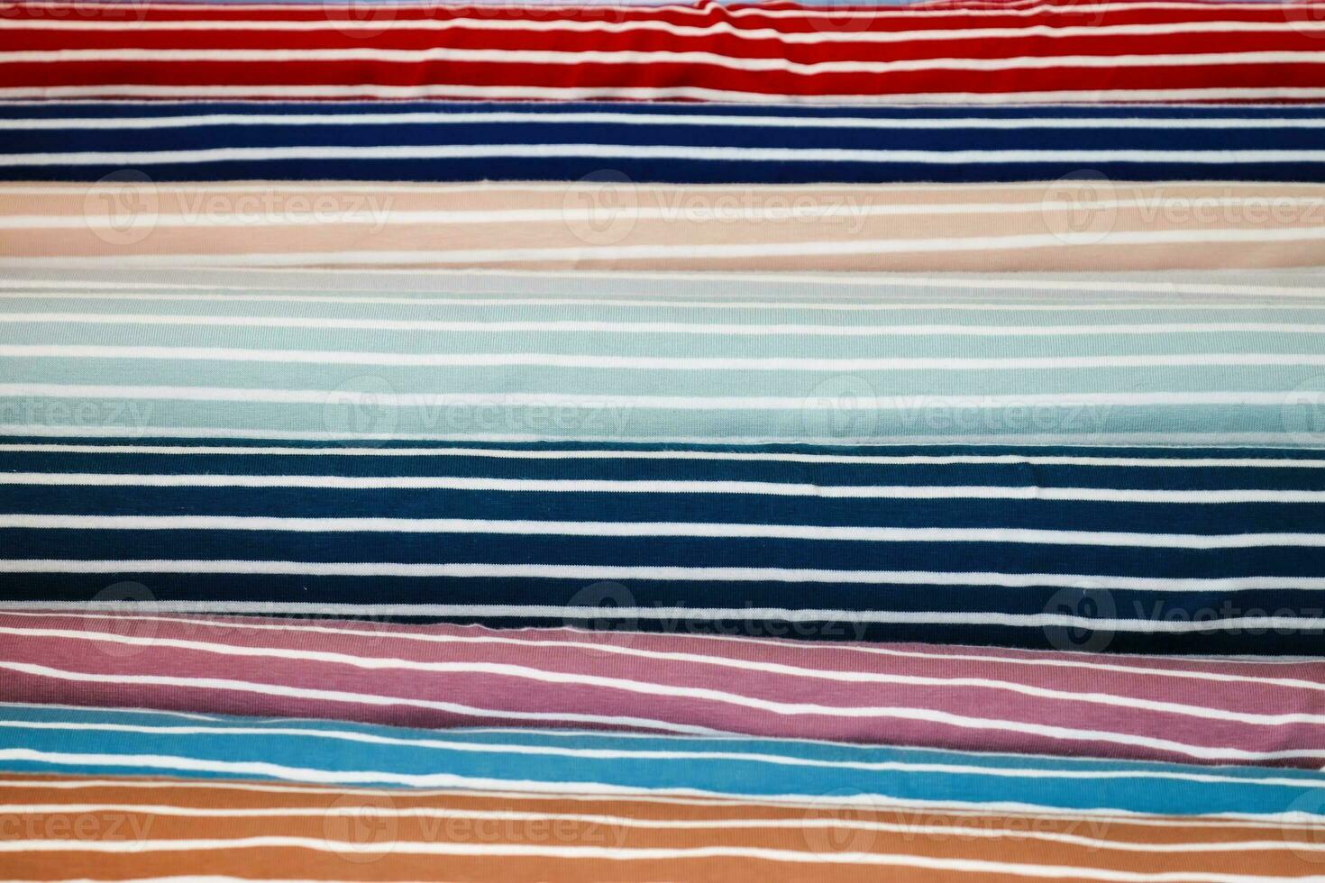 Detailed close up view on samples of cloth and fabrics in different colors found at a fabrics market photo