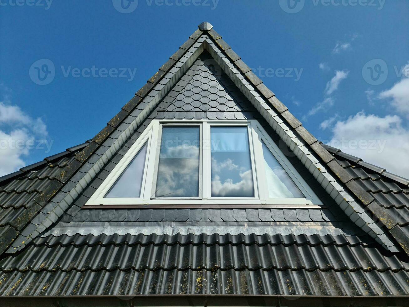 Open roof window in velux style with black roof tiles. photo