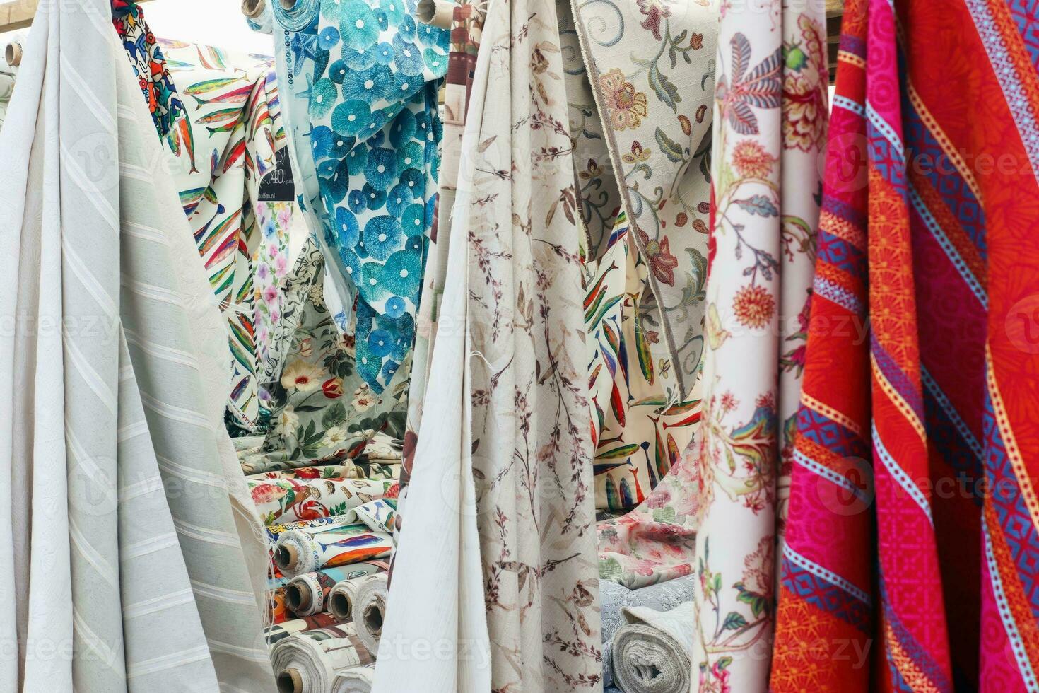 Detailed close up view on samples of cloth and fabrics in different colors found at a fabrics market photo