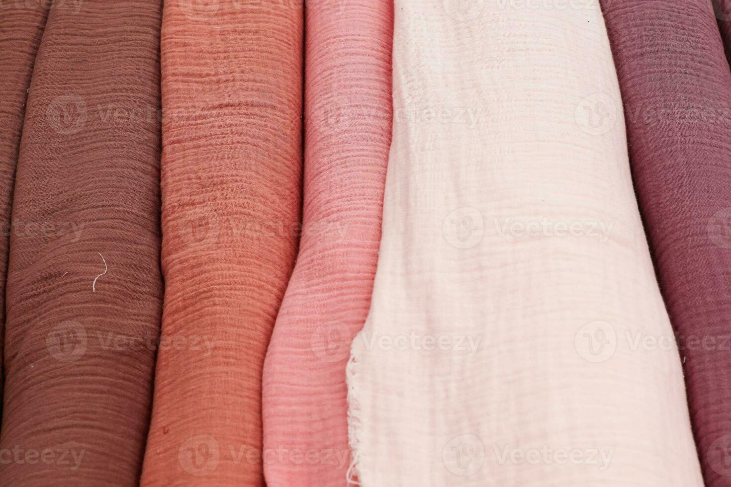Detailed close up view on samples of cloth and fabrics in different colors found at a fabrics market photo
