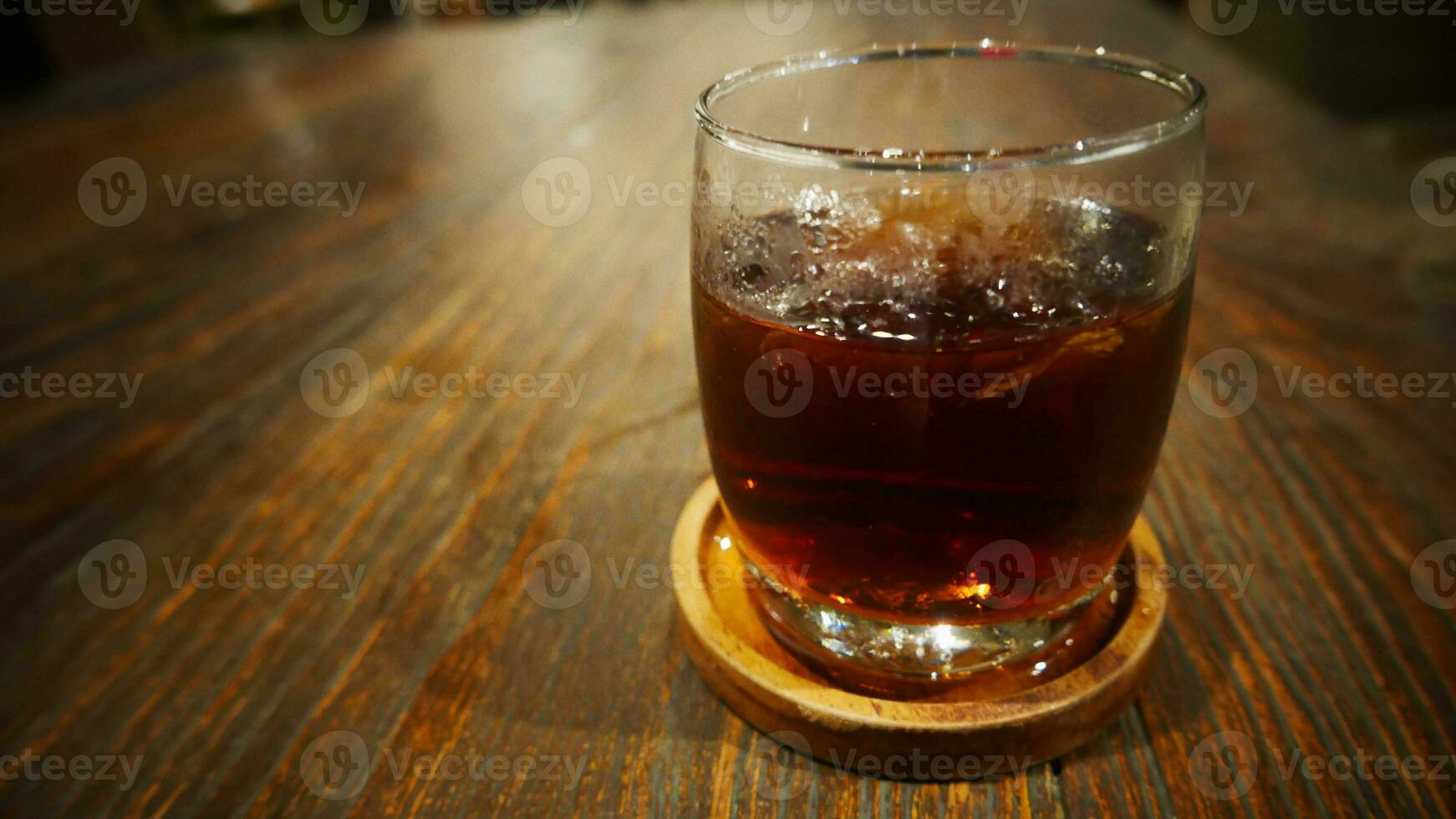 Transparent Glasses with sweet drinks inside with coke drink, with shadow and table background with ice cubes on a bar restaurant photo