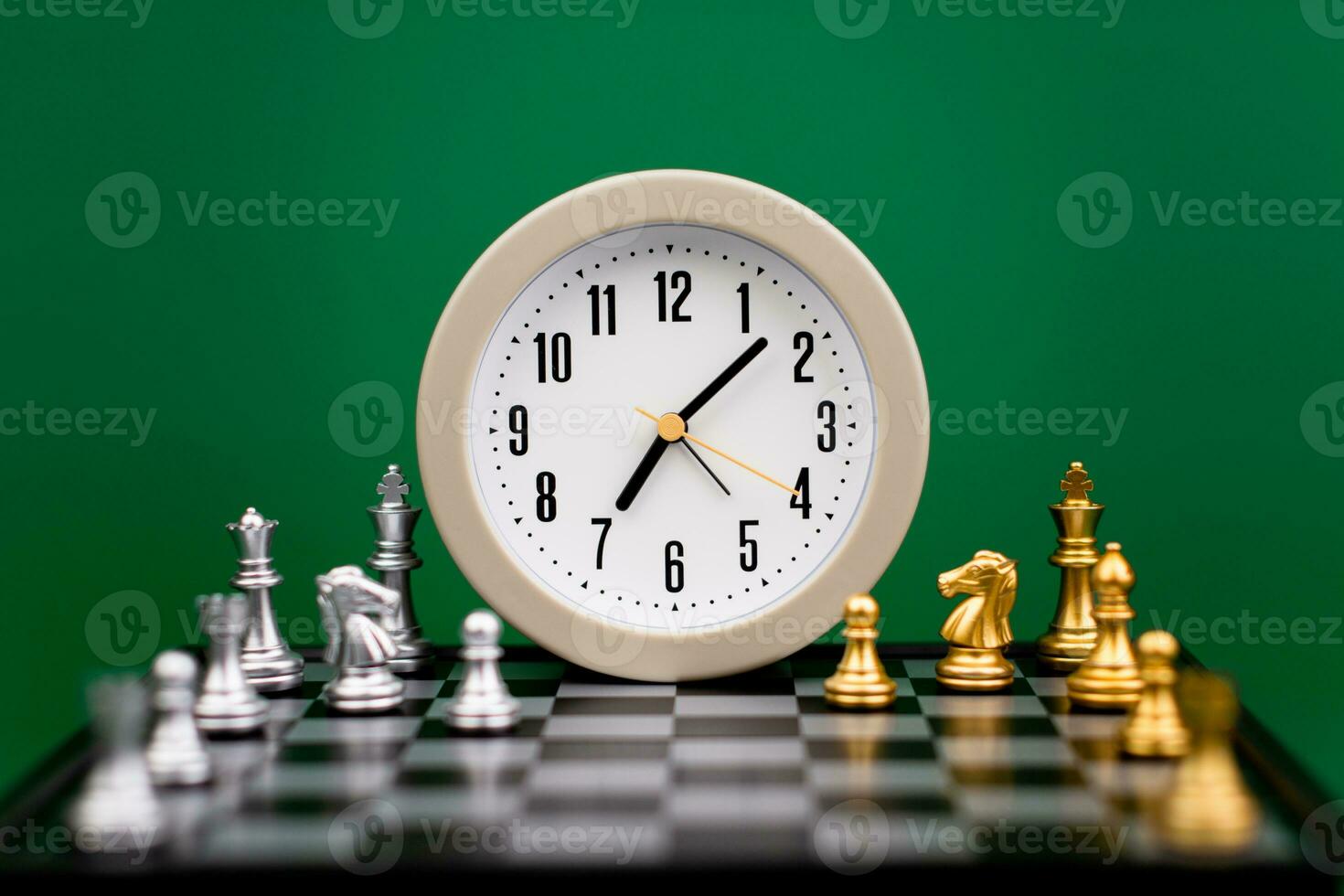 alarm clock on chess table time strategy plan work with time green backdrop Working with time. Be on time. Keep time. Value time concept. photo