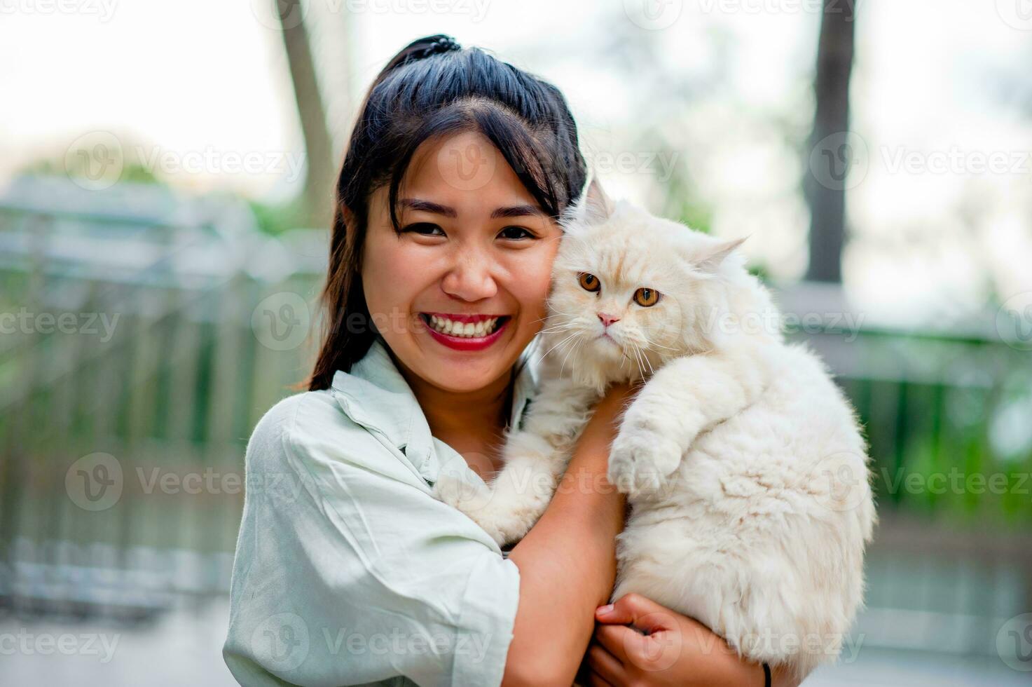 Woman holding cat playing at home with love for cats The smile glints in his bond with his fluffy pet cat. The relationship of people and cats, cat owners, domestic cats, fat cats photo