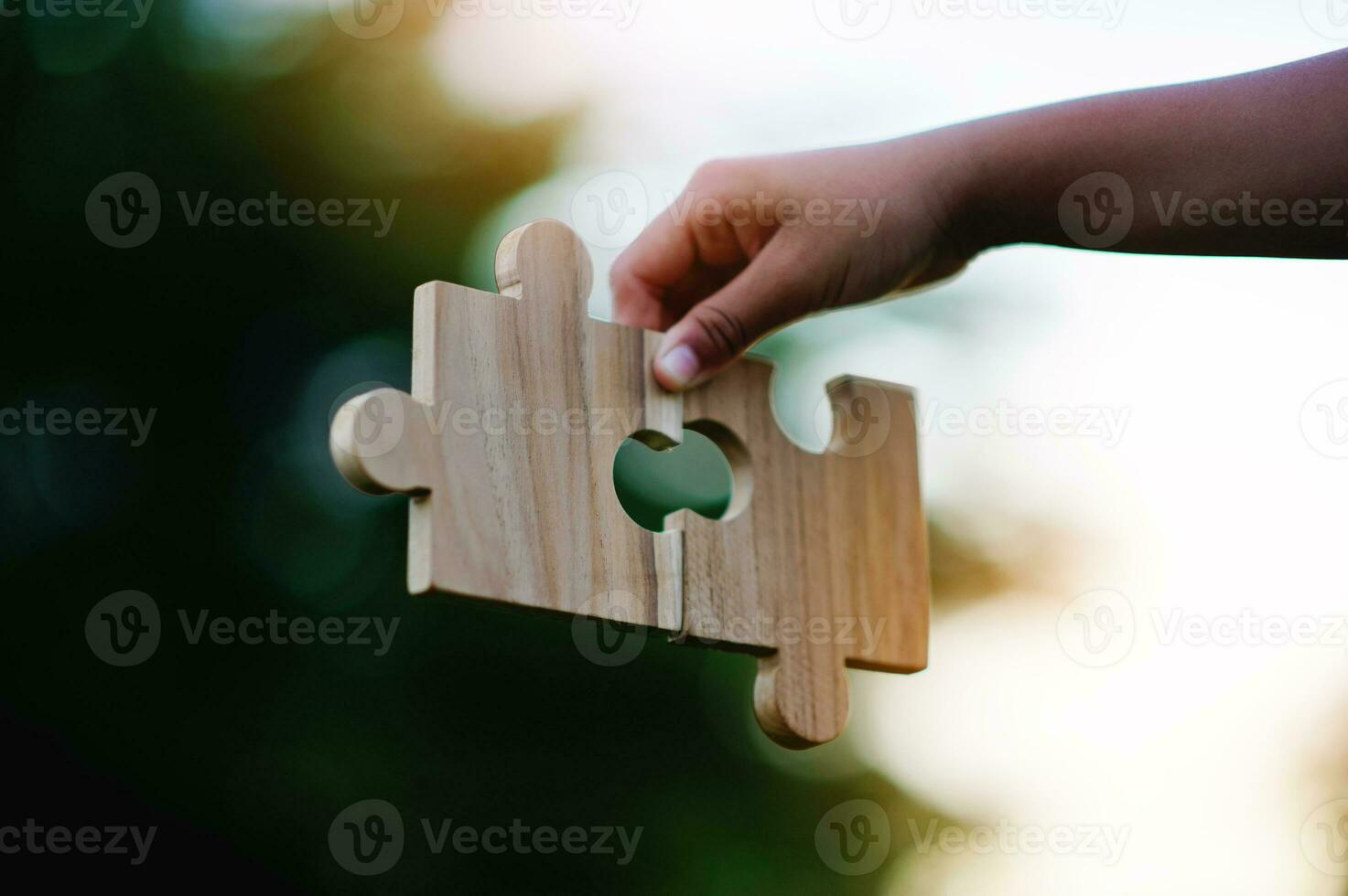 Jigsaw in hand, a puzzle piece that is critical to success. Creativity, ideas, initiative, unity, teamwork photo