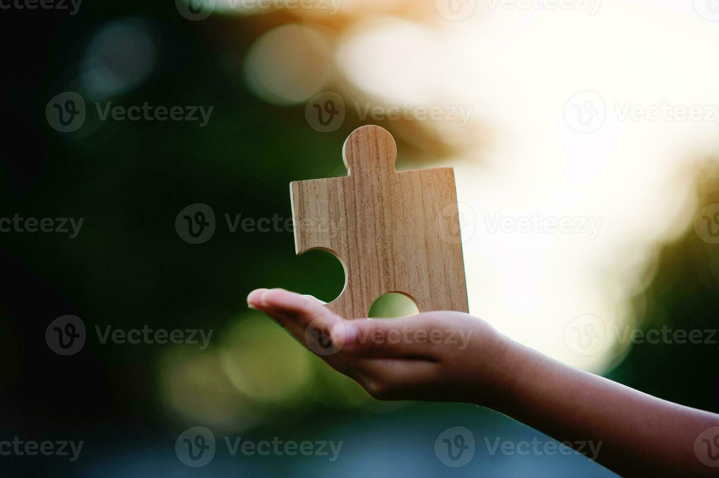 Jigsaw in hand, a puzzle piece that is critical to success. Creativity, ideas, initiative, unity, teamwork photo