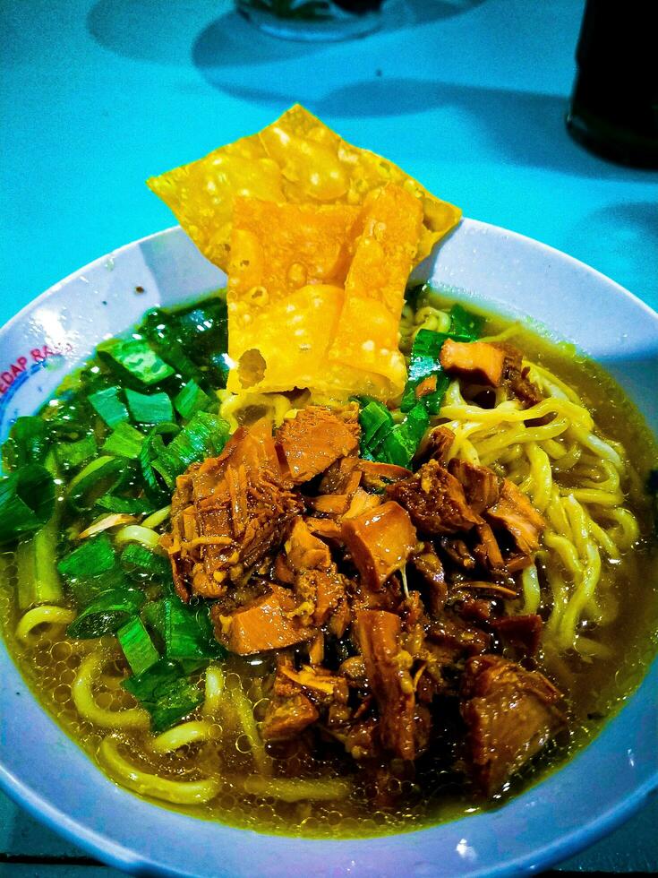 Mie ayam is a food from Indonesia which is made from noodles mixed with chicken photo