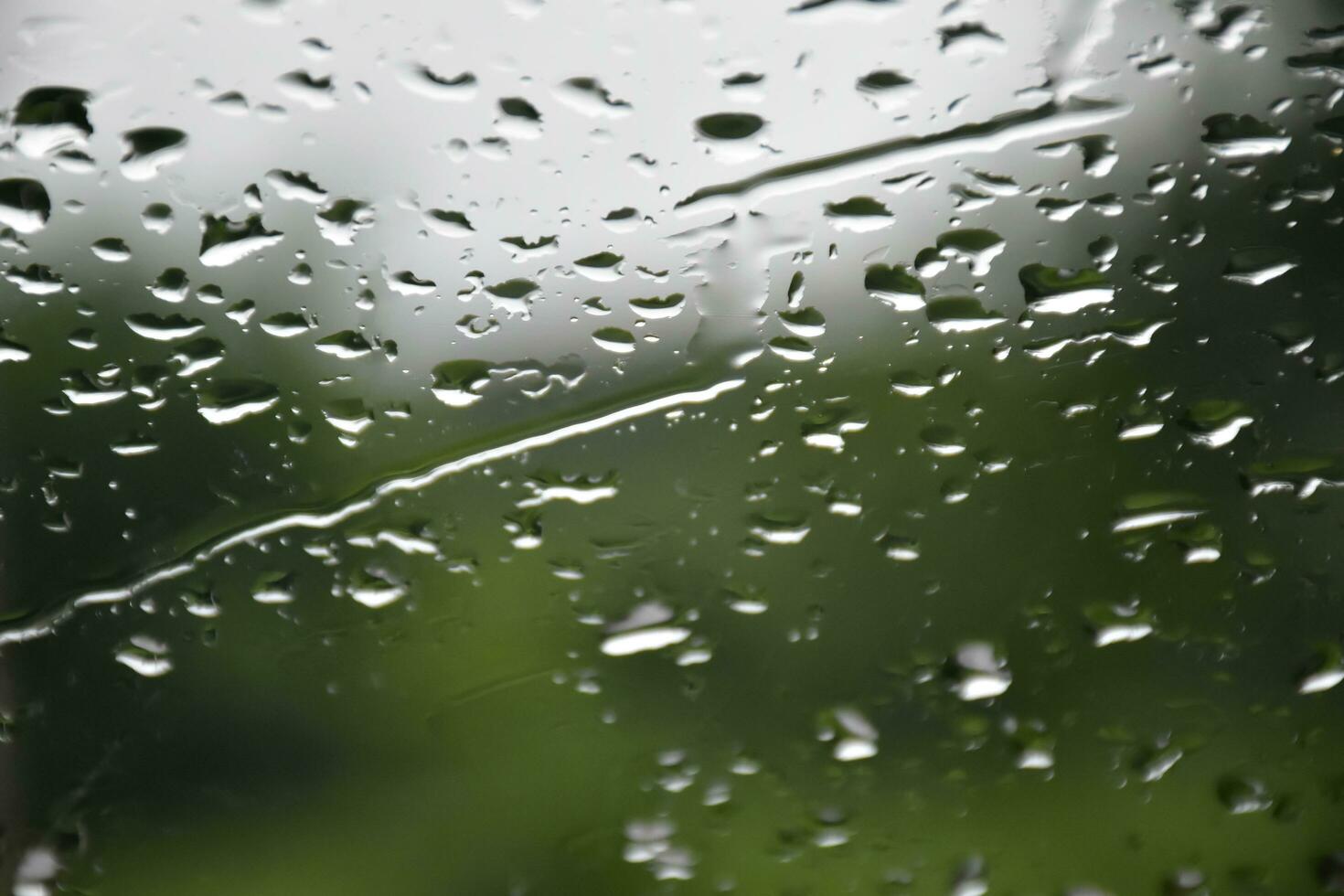 Blurred image of raindrops on the rear view mirror of car, soft focus photo